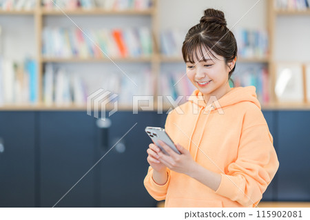 A young woman operating a smartphone. A young woman operating a smartphone. 115902081