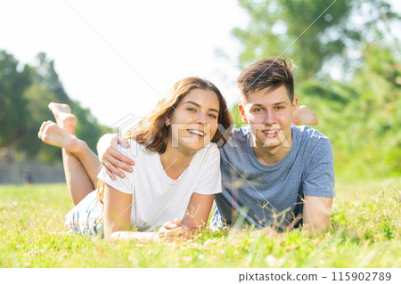 Cheerful girl with friend are resting on grass 115902789