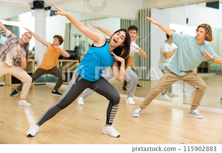 Expressive hispanic teenage girl practicing energetic dance movements 115902883