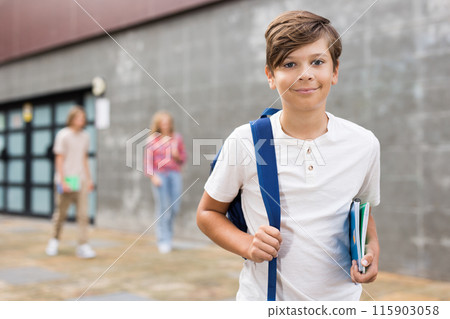 Teen boy walk along summer street after finishing college lessons 115903058