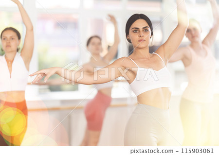 Young girl mastering ballet moves at group class Young girl mastering ballet moves at group class 115903061