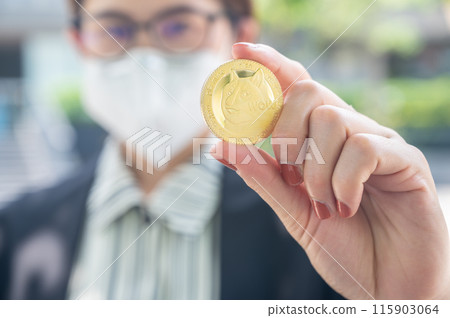 Businesswoman holding a Dogecoin token. Dogecoin is a cryptocurrency, a form of digital money that, much like bitcoin but created as a joke. 115903064