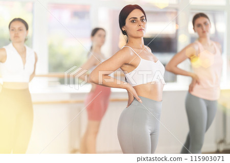 Close-up view of young girl practicing ballet positions standing in row 115903071