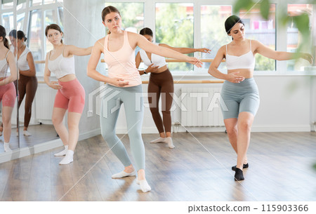 Teenage girl participating in beginner group ballet class 115903366