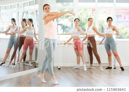 Girls in sportswear rehearsing ballet poses in choreographic studio 115903641