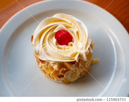 Sponge cake with vanilla frosting and almonds 115903731