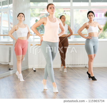 Group of oung ballerinas rehearsing ballet movements in the choreography studio 115903734