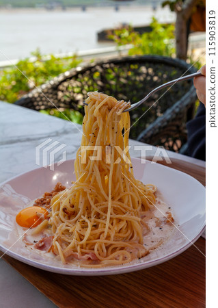 Holding pasta noodles with a fork 115903819