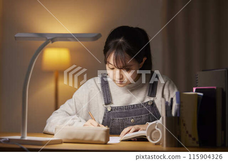 A high school girl studying for an exam in her room A high school girl studying for an exam in her room 115904326