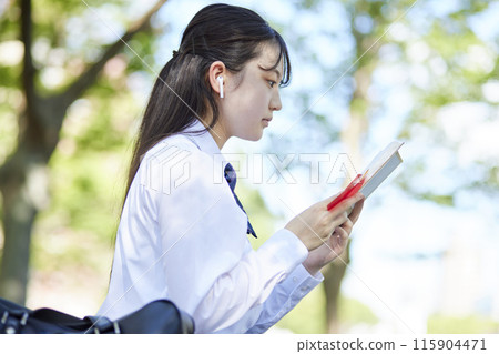 High school girl studying with a reference book High school girl studying with a reference book 115904471