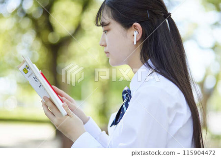 High school girl studying with a reference book High school girl studying with a reference book 115904472