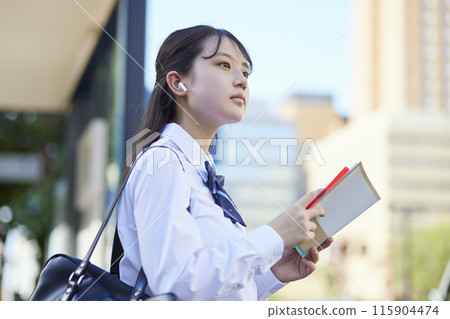 High school girl studying with a reference book High school girl studying with a reference book 115904474