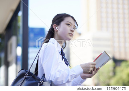 High school girl studying with a reference book High school girl studying with a reference book 115904475