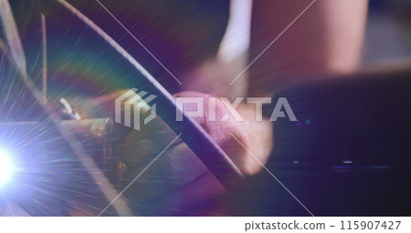 Image of illuminated light beam over hands of caucasian mechanic fixing car screw in garage 115907427