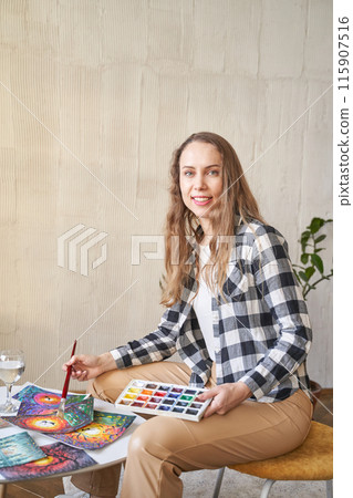 Woman holding paint brush at hand. Watercolor color palette. Art drawing process Woman holding paint brush at hand. Watercolor color palette. Art drawing process 115907516