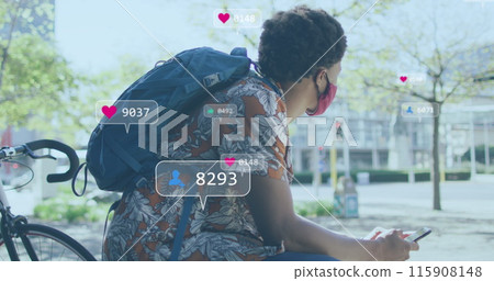 Image of social media icons over african american man with face mask using smartphone Image of social media icons over african american man with face mask using smartphone 115908148