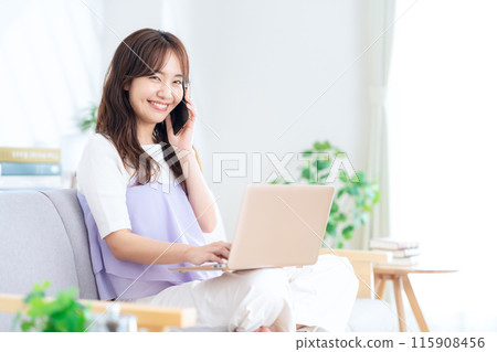 一個年輕女子在客廳裡看電腦 115908456