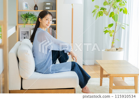 Woman relaxing in the living room 115910534