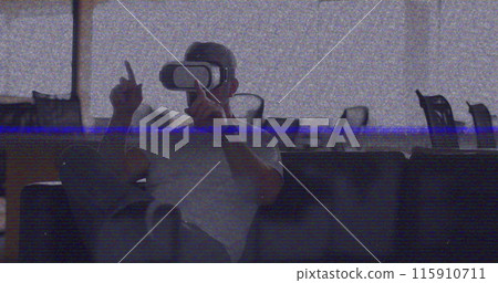 Image of vhs glitch effect over caucasian man wearing vr headset at office 115910711