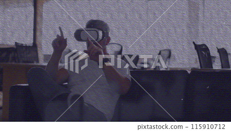 Image of vhs glitch effect over caucasian man wearing vr headset at office 115910712