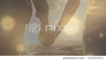 Image of glowing spots over diverse couple holding hands 115910721