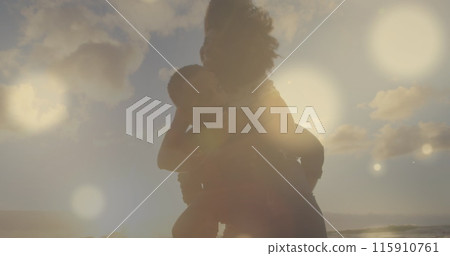 Image of glowing spots over diverse couple embracing Image of glowing spots over diverse couple embracing 115910761