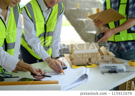 Engineer team having briefing about project reviewing blueprints at a building site Engineer team having briefing about project reviewing blueprints at a building site 115911079
