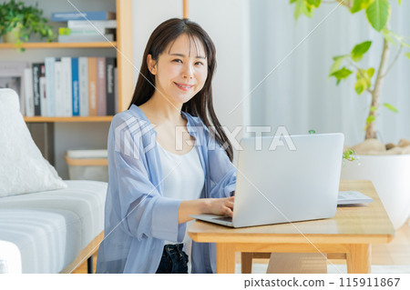 Young woman working on a laptop at home Young woman working on a laptop at home 115911867