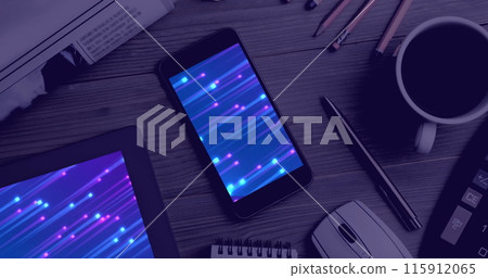 Image of technological devices with light trails on screen on desk 115912065
