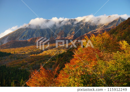 Clouds rising from the south wall of Mt. Oyama and autumn leaves seen from Kagikake Pass with a blue sky in the background Ver2 115912249