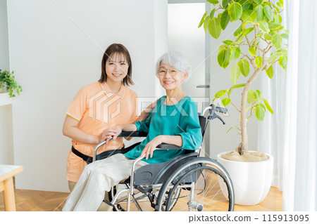 Caregiver supporting a woman in a wheelchair Caregiver supporting a woman in a wheelchair 115913095