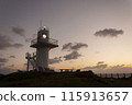 A lighthouse illuminated by the sunset 115913657