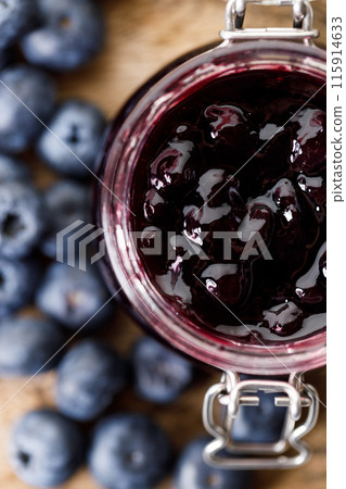 Blueberry jam with fresh berries on rustic wooden table background. Selective focus. 115914633
