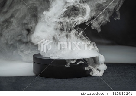 Round black box emitting smoke from dry ice on dark background Round black box emitting smoke from dry ice on dark background 115915245