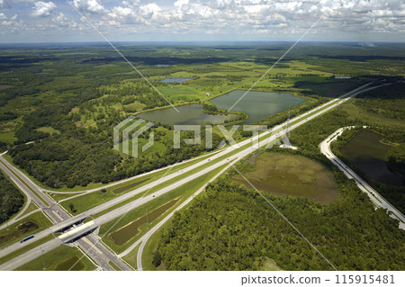 Aerial view of freeway overpass junction with fast moving traffic cars and trucks. Interstate transportation infrastructure in USA 115915481
