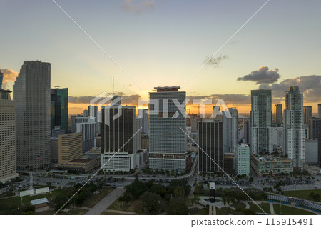 Aerial view of downtown district of of Miami Brickell in Florida, USA at sunset. High skyscraper buildings and street with cars and Metrorail traffic in modern american midtown 115915491