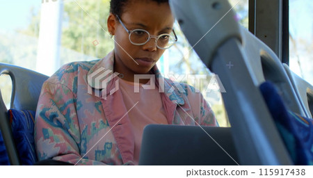 Abstract colorful shapes against african american woman using laptop in the bus Abstract colorful shapes against african american woman using laptop in the bus 115917438