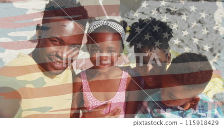This image shows an african american family smiling and taking a selfie at the beach 115918429