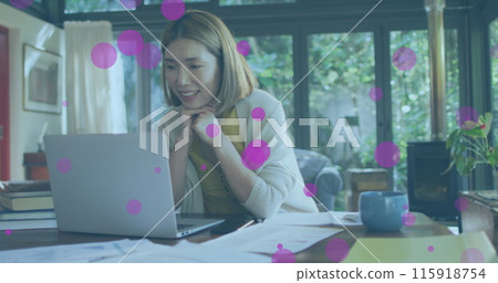 Image of pink spots floating over asian woman having a image call on laptop at home Image of pink spots floating over asian woman having a image call on laptop at home 115918754