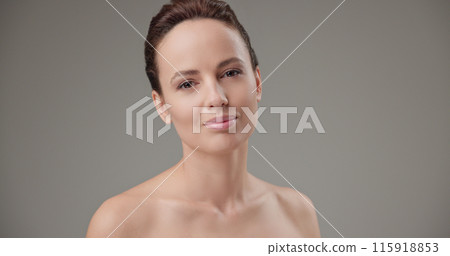 Beauty, health, cosmetics, anti-aging therapy and skin care concept - young beautiful brunette Caucasian woman touching face and looking at camera 115918853
