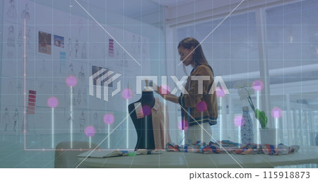 Image of computer language and graph on biracial female designer checking design of dress 115918873
