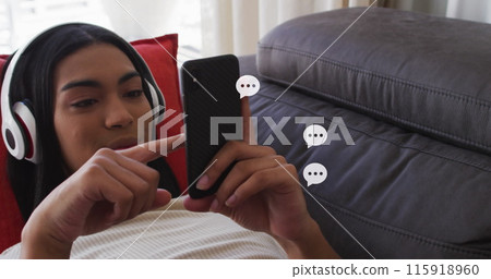 Image of social media icons over biracial woman using smartphone Image of social media icons over biracial woman using smartphone 115918960