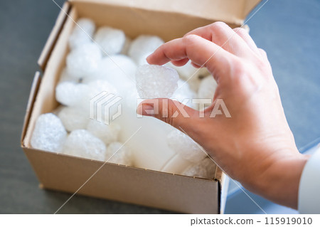Eco packaging of parcels and white biodegradable filler. Box is filled with a filler safety for environment. Delivery of goods, parcels, delivery service, nature protection and recycling concept Eco packaging of parcels and white biodegradable filler. Box is filled with a filler safety for environment. Delivery of goods, parcels, delivery service, nature protection and recycling concept 115919010