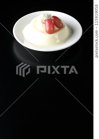 Panna cotta with cream and grapes photographed against a black background Panna cotta with cream and grapes photographed against a black background 115919058