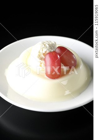 Panna cotta with cream and grapes photographed against a black background Panna cotta with cream and grapes photographed against a black background 115919065