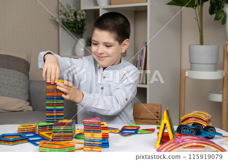 Boy building a tower from a magnetic construction set 115919079