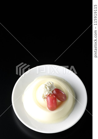 Panna cotta with cream and grapes, shot from above on a black background Panna cotta with cream and grapes, shot from above on a black background 115919115