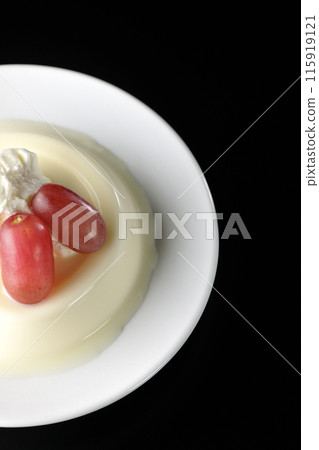 Panna cotta with cream and grapes, shot from above on a black background 115919121