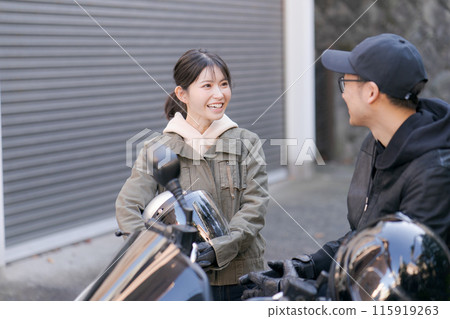 Man and woman talking on a motorcycle 115919263