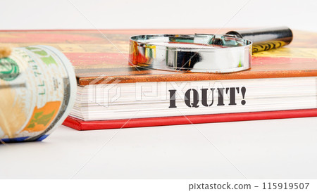 I Quit word on the end of the book on a white background and compositions with a magnifying glass and money 115919507